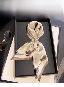 Detail of 100% mulberry silk twilly scarf with carriage print and champagne gold finish