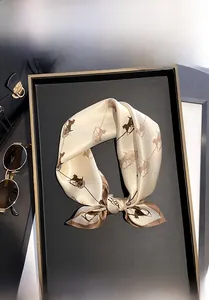 Detail of 100% mulberry silk square scarf with horse carriage print on a display tray