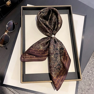 Détail d'un foulard en soie de mûrier à motif paisley avec une boucle en perle