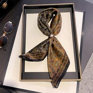 Foulard en soie avec imprimé cachemire et boucle perle sur plateau noir