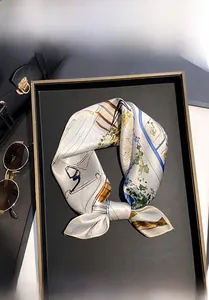 Vue détaillée d'un foulard en soie de mûrier 100% noué sur un sac à main de luxe