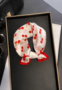 Detail of 100% mulberry silk scarf featuring cherry print and red rolled edges