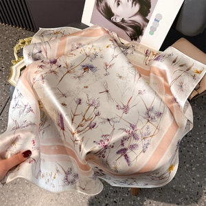 Gros plan d'un foulard en soie imprimé avec motif floral et bords rayés roses