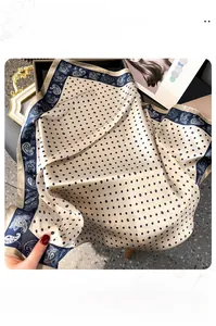 Detailed view of silk square scarf featuring black polka dots and blue paisley borders