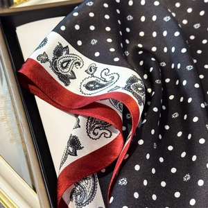 Detail of silk scarf showing polka dot patterns and paisley print with smooth texture