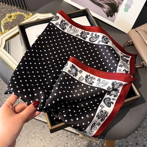 Detail of silk scarf with classic polka dots and paisley borders in a premium layout