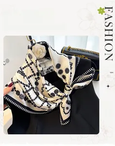 Detail of silk scarf tied at neck showing black and white vintage print and smooth texture
