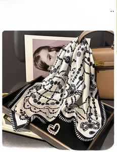 Detail of silk square scarf with dot and chain pattern and a heart pearl brooch