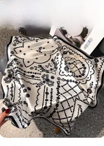 Detail of silk square scarf featuring leopard print, bow motifs, and striped borders