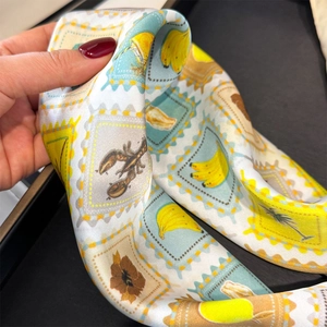 Detail of silk scarf with stamp print featuring banana and floral patterns