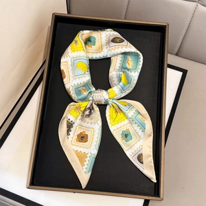 Elegant fruit print silk neckerchief tied in a bow on a black display tray