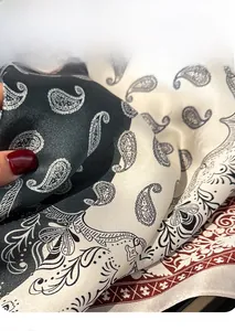 Detailed view of paisley silk scarf showing soft drape and satin luster texture