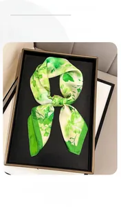 Detail of silk scarf with floral print and soft texture tied on a display tray