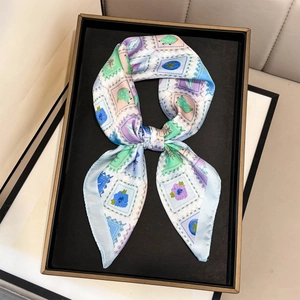Detail of light blue silk scarf with vintage stamp fruit floral patterns in a tray