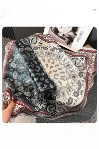 Detail of vintage paisley print silk scarf with fine stitching and wine red border