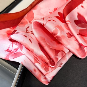 Detailed macro view of smooth silk scarf texture with pink floral ink painting patterns