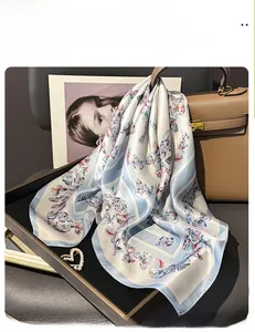 Détail d'un carré de soie avec imprimé papillon coloré sur tissu bleu clair et beige
