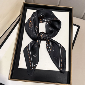 Detailed view of paisley silk scarf with vintage orange pattern on black background