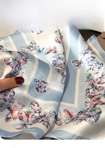 Gros plan sur la texture du foulard en soie avec imprimé papillon et procédé d'impression