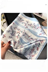 Détail du foulard en soie avec bordure fine et motifs de papillons élégants
