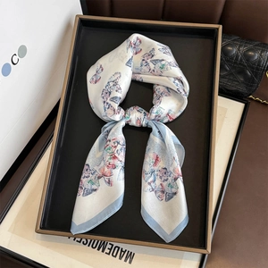 Élégant foulard en soie avec imprimé papillon bleu sur crème, noué de façon chic