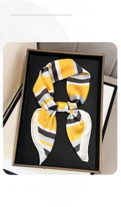 Detail of silk scarf with geometric yellow and grey stripes in an elegant bow shape
