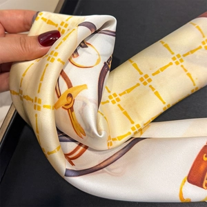 Detailed view of luxury chain print scarf showing soft silk texture and draping