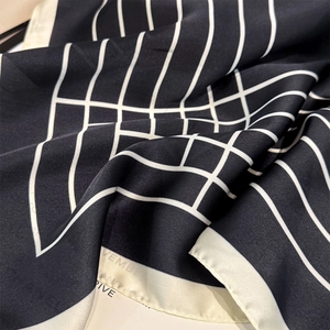 Detail of premium silk-like square scarf featuring classic black and white geometric patterns