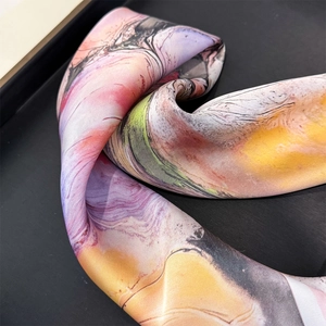 Detailed macro shot of the silk scarf featuring artistic oil painting floral marble patterns
