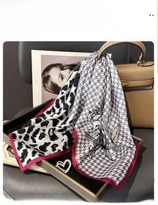 Detail of a silk scarf with leopard print, houndstooth, and floral patterns on a handbag