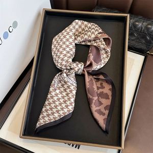 Silk scarf with houndstooth and leopard print presented on a luxury display tray
