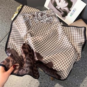 Detailed texture of silk square scarf featuring houndstooth, floral, and leopard prints