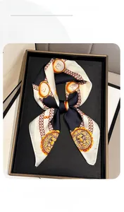 Detailed view of square silk scarf with gold chain and lion coin print in black and white