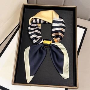 Close-up of geometric striped silk scarf with navy and ginger blocks on a display tray
