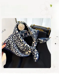 Dettaglio di un foulard in seta bianco e blu con motivi floreali e parasole chic