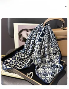 Dettaglio del foulard in 100% seta di gelso con stampa floreale su una borsa di marca