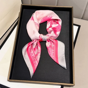 Luxurious pink silk square scarf featuring elegant horse and sun prints in a tray