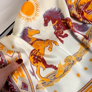 Detailed view of horse print silk scarf with luxury geometric patterns and orange border