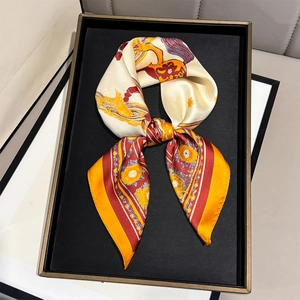 Close-up of elegant horse print silk scarf tied in a bow on a luxury display tray