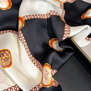 Elegant silk scarf with lion head motif and golden chain border in black and white