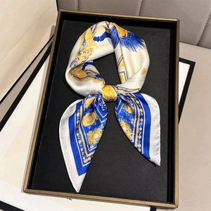 Baroque style horse print silk scarf in blue and gold presented on a black luxury tray