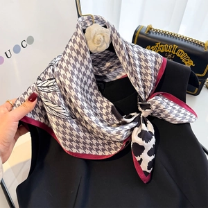 Silk square scarf with houndstooth and leaf patterns tied to a black top collar