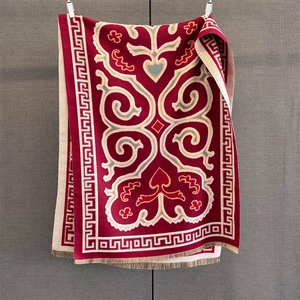 Close-up of elegant red and white scroll pattern scarf with delicate fringe edges
