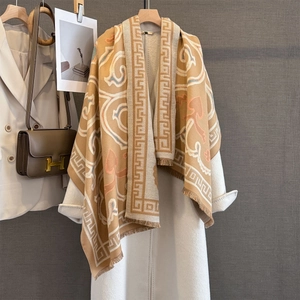 Detailed view of camel jacquard shawl with tassel fringe and elegant scroll patterns