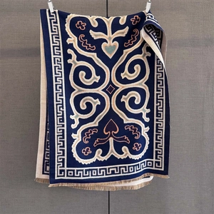 Detailed view of dark blue winter shawl with ethnic floral pattern and fringe hem