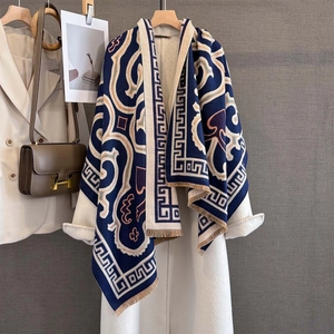 Detailed view of winter thick scarf with geometric patterns and fringe edges on a coat
