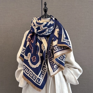 Detail of navy knit scarf showing jacquard floral patterns and delicate short fringe edges