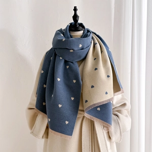 Close-up of blue and yellow double-sided heart pattern scarf with delicate fringes
