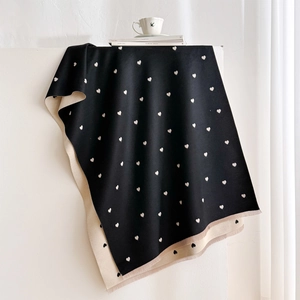 Reversible heart jacquard cashmere-feel scarf with frayed edges on a minimalist display