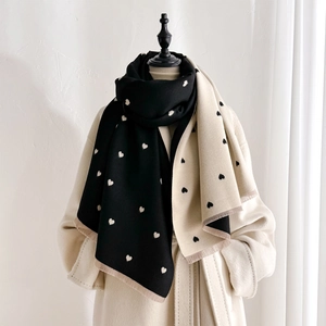 Detail showing double-sided heart pattern and soft fringed edges of the cashmere scarf